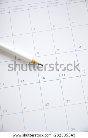 white pencil point to date fifteen on blank calendar