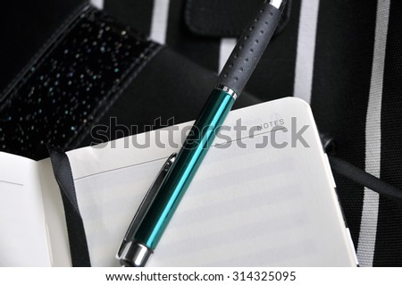 green color pen put on blank notebook page