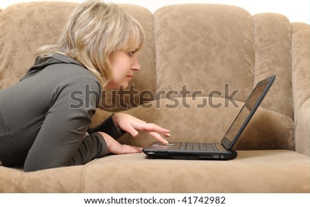 The woman working on laptop at home. House conditions, a sofa.