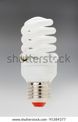 Energy saving compact fluorescent lightbulb on a grey gradient