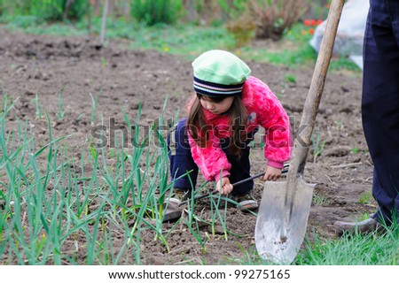 The little girl works in the garden. Autumn