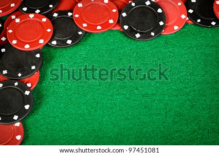 Red and black gambling chips on a green felt table background