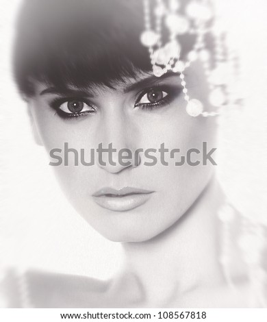 black and white image of portrait of a beautiful brunette girl with healthy beautiful hair and  glossy face,  photographed in the studio against a plain white background