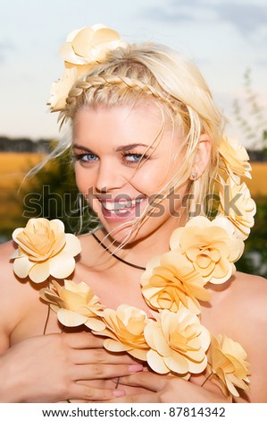 a beautiful young girl with a beaming smile flower decoration in her hair on nature background