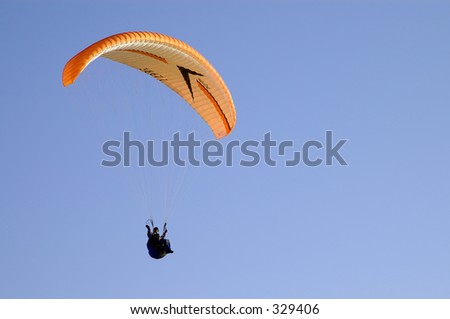 Paraglider waving hello, clear blue sky