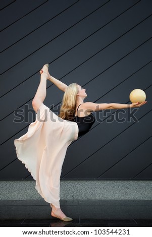 Beautiful blonde girl dancing with ball outdoor