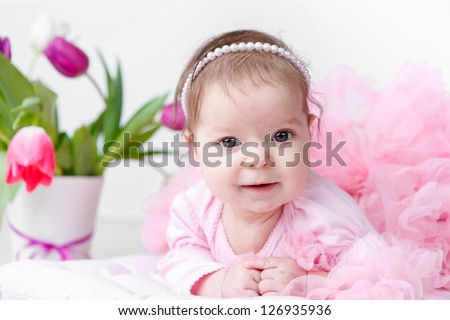 adorable baby girl with spring flowers