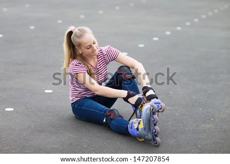 Roller skate girl skating. Young woman putting on skates going rollerblading in urban city park