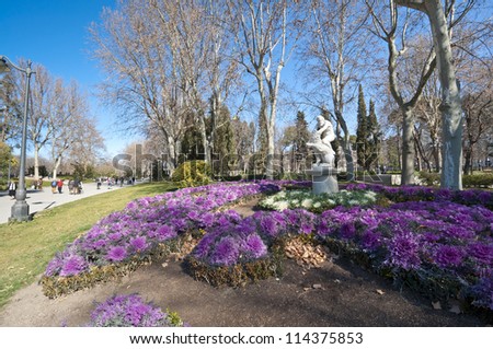 Flower bed at Retiro Park, Madrid, Spain. The statue depicts Hercules slaying Nemean lion.