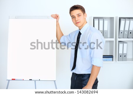Young businessman with a flip chart during a presentation in office