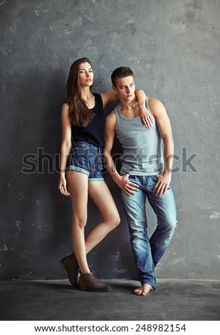 fashion beautiful young couple on grey wall background