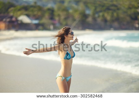 Happy freedom woman enjoying summer on the tropical beach. Feedom concept.