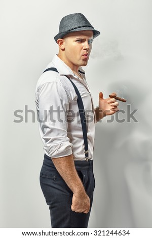 Side view of a stylish young man smoking cigar