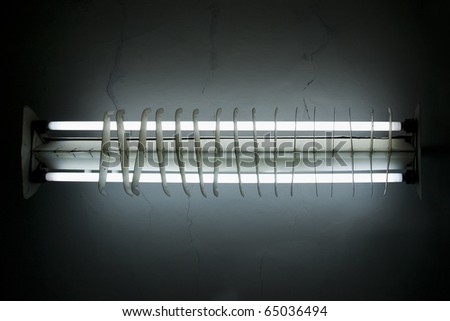 Old fluorescent light tube shining ray on dark background