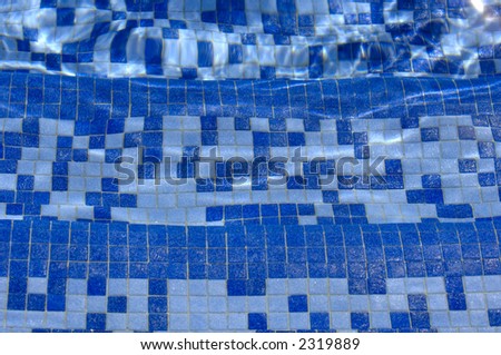 Three tiled swimming pool steps underwater with light reflections. Focus = the middle step. 12MP camera.