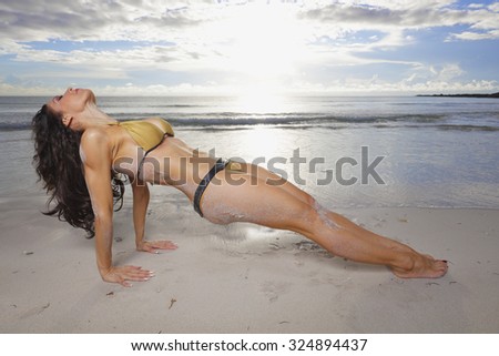 Woman in a fitness pose on the beach
