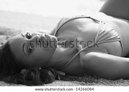 Black And White Image Of A Woman Laying On The Sand
