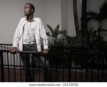 Young African American male leaning on a rail