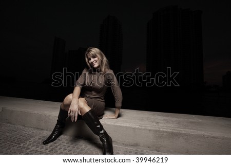 Woman sitting on a ledge in the dark