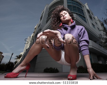 Ground angle view of a woman squatting and trying to grab the camera