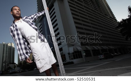 Teenager hanging from a pole in the city