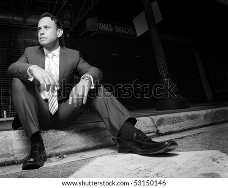 Businessman sitting on the curb.  Image in black and white