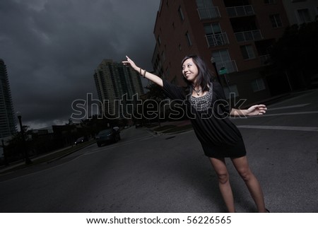 Young woman reaching her hands out towards the street