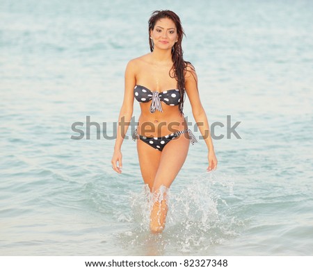 Attractive bikini model walking out of the ocean