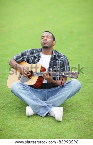 Handsome black man playing guitar with his eyes closed