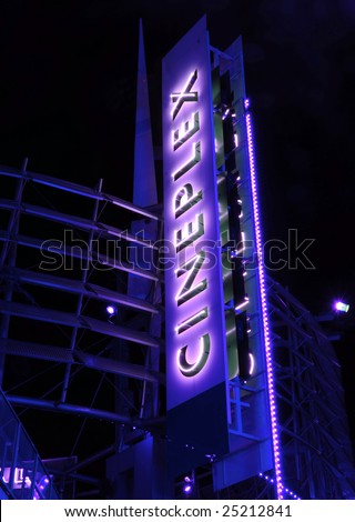 Giant vertical neon sign advetising movie theater