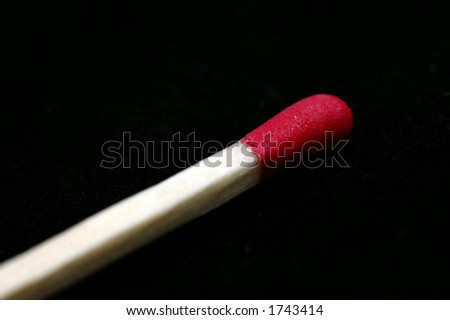Closeup of a Red Tipped wooden match stick against a black background