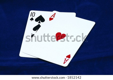 Blackjack! Closeup of Blackjack against a blue background.  Ten (10) of Spades behind Ace of Hearts.