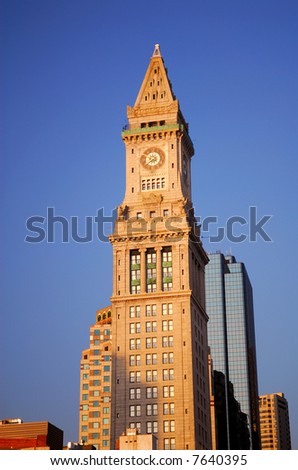 Customs building tower in Boston with clock in early morning light against a blue sky