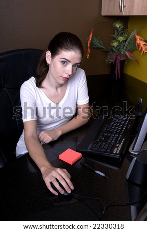 Lovely brunette female at her office workstation