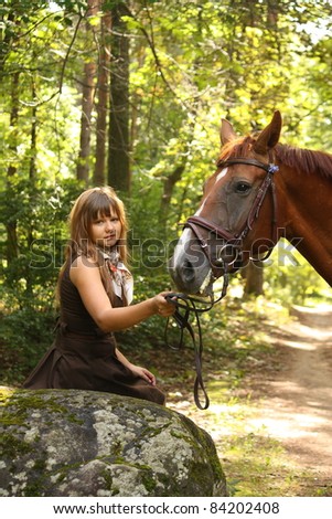 Beautiful teenager girl and chestnut horse in the forest un summer
