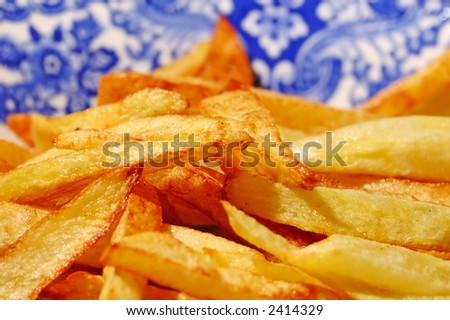 fried fresh potatoes in a blue white dish (extreme closeup )