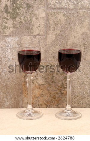 two glasses of wine in dark stones wall background
