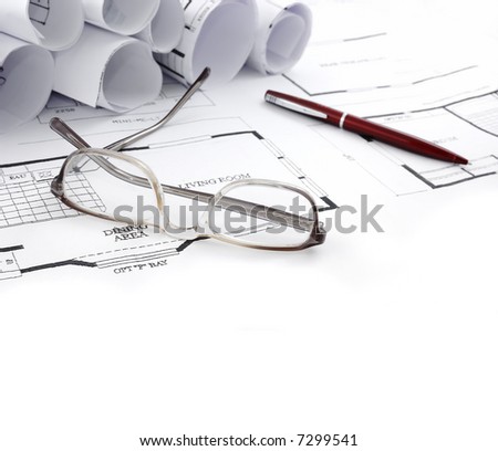 house plans and glasses on it with a pen