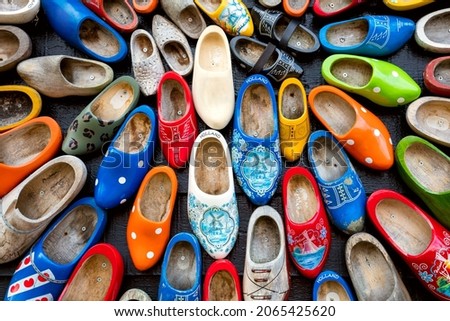 Old wooden Dutch shoes - klomps. A lot of colorful old clomps against the background of a wooden wall. Popular souvenirs. Traditions of Holland. Background Foto stock © 
