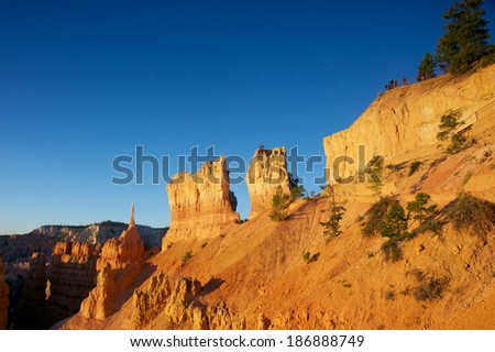 Tourists stand along a cliff edge railing in Bryce Canyon National Park in Utah\'s southwest.
