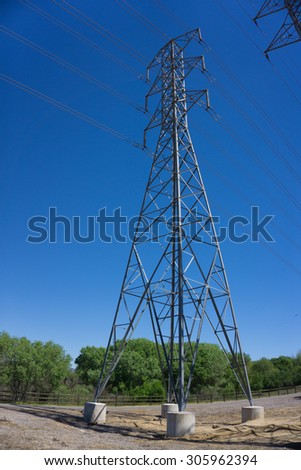 Tall metal power line tower above a walking path in Santa Clarita California.