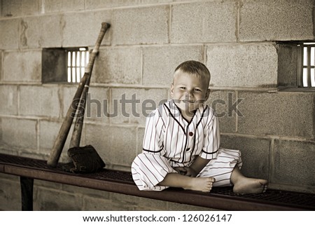 Adorable little boy in an old time baseball uniform.  Special editing to give the photo an old time feel.