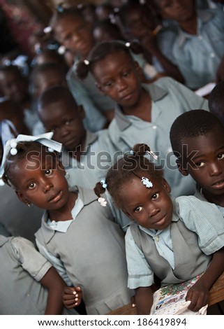 KOLMINY, HAITI - FEBRUARY 12, 2014 - Crowded Haitian classroom.  Shallow depth of field with focus on the young girl in the front and center.