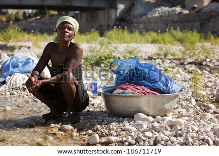 MONTROUIS, HAITI.  FEBRUARY 7, 2014.  Haitian women by the stream with her wash.