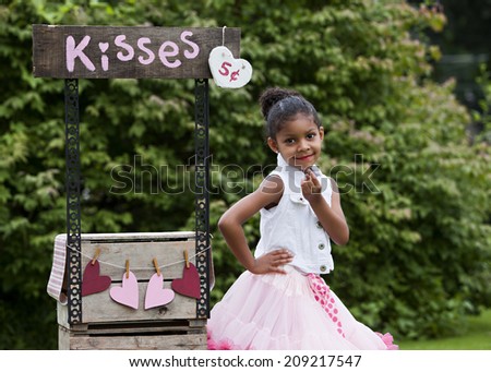 Kissing Booth.  Adorable little girl pretending to be running a kissing booth.
