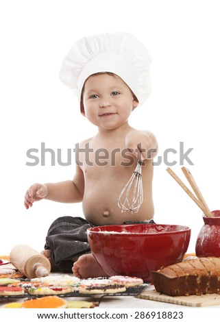 Little Baker.  Adorable little boy wearing a chef\'s hat and surrounded by baked goods.  Isolated on white.