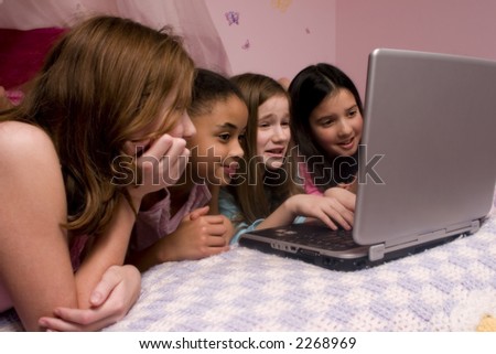 Friends playing on the computer at a slumber party.