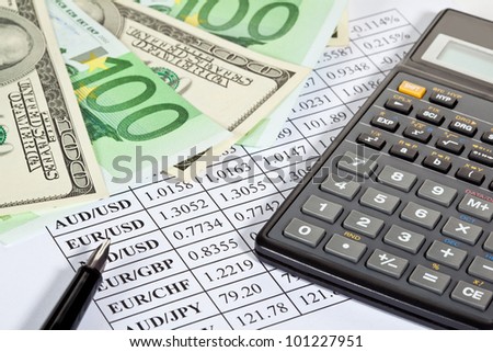 Business analytics: closeup of paper money, calculator and pen on currency cross-rate table