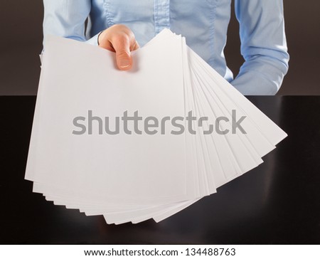 Hand reaching out blank documents to you, copy space