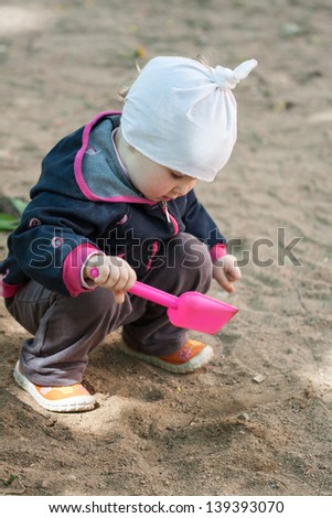Little girl playing in a sandpit
